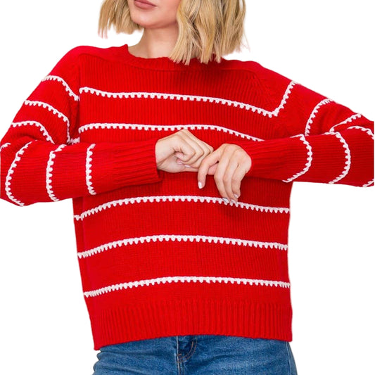 Person wearing a red sweater with white stripes against a plain background