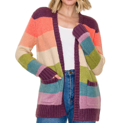 Woman wearing a colorful striped cardigan on a plain background