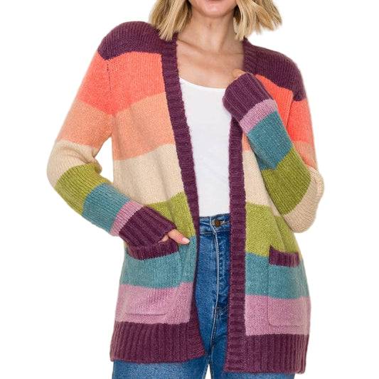 Woman wearing a colorful striped cardigan on a plain background