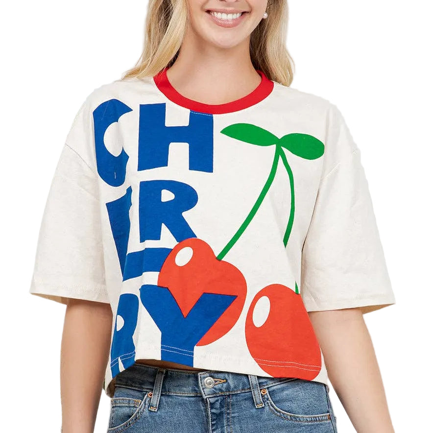 Woman wearing a colorful 'CHERRY' t-shirt with cherries graphic against a white background