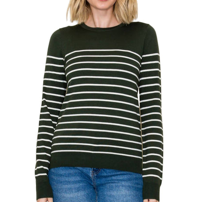 A woman wearing a forest green and white striped sweater against a plain background