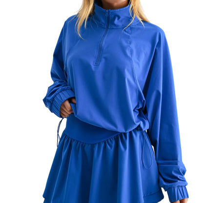 Woman wearing a blue outfit with a high collar on a white background