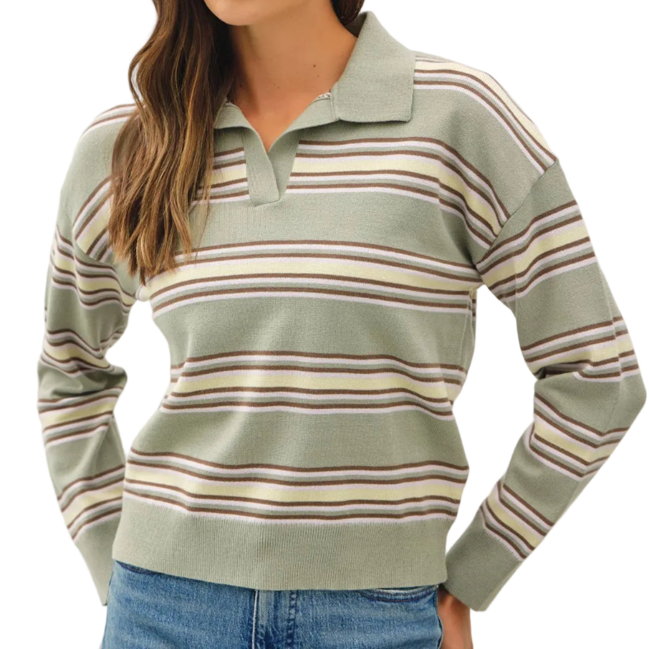 A woman wearing a sage green long-sleeve polo sweater with horizontal stripes in beige, brown, and muted pink, paired with blue jeans, against a plain light gray studio background.