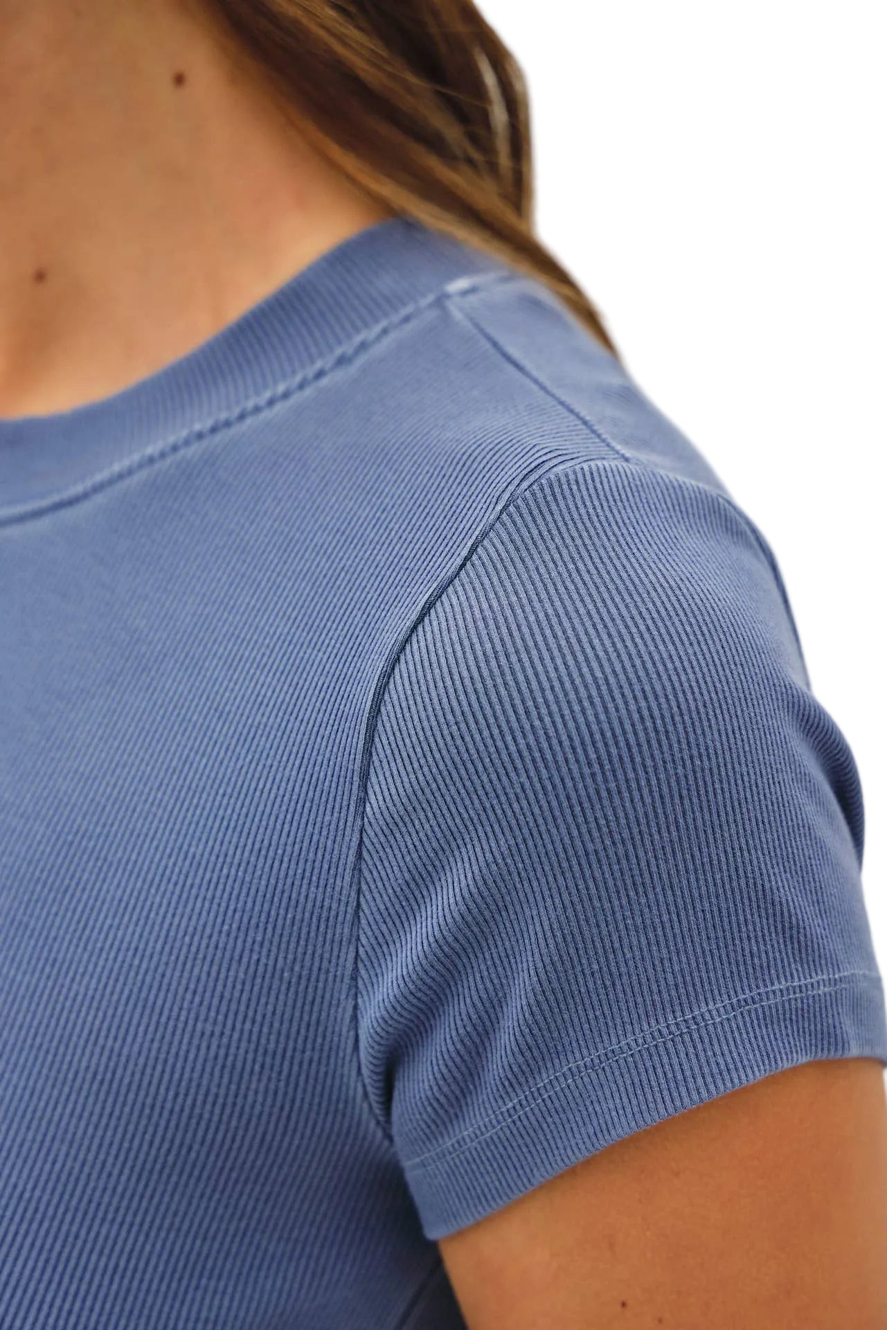 Close-up of a person wearing a blue short-sleeve shirt against a white background
