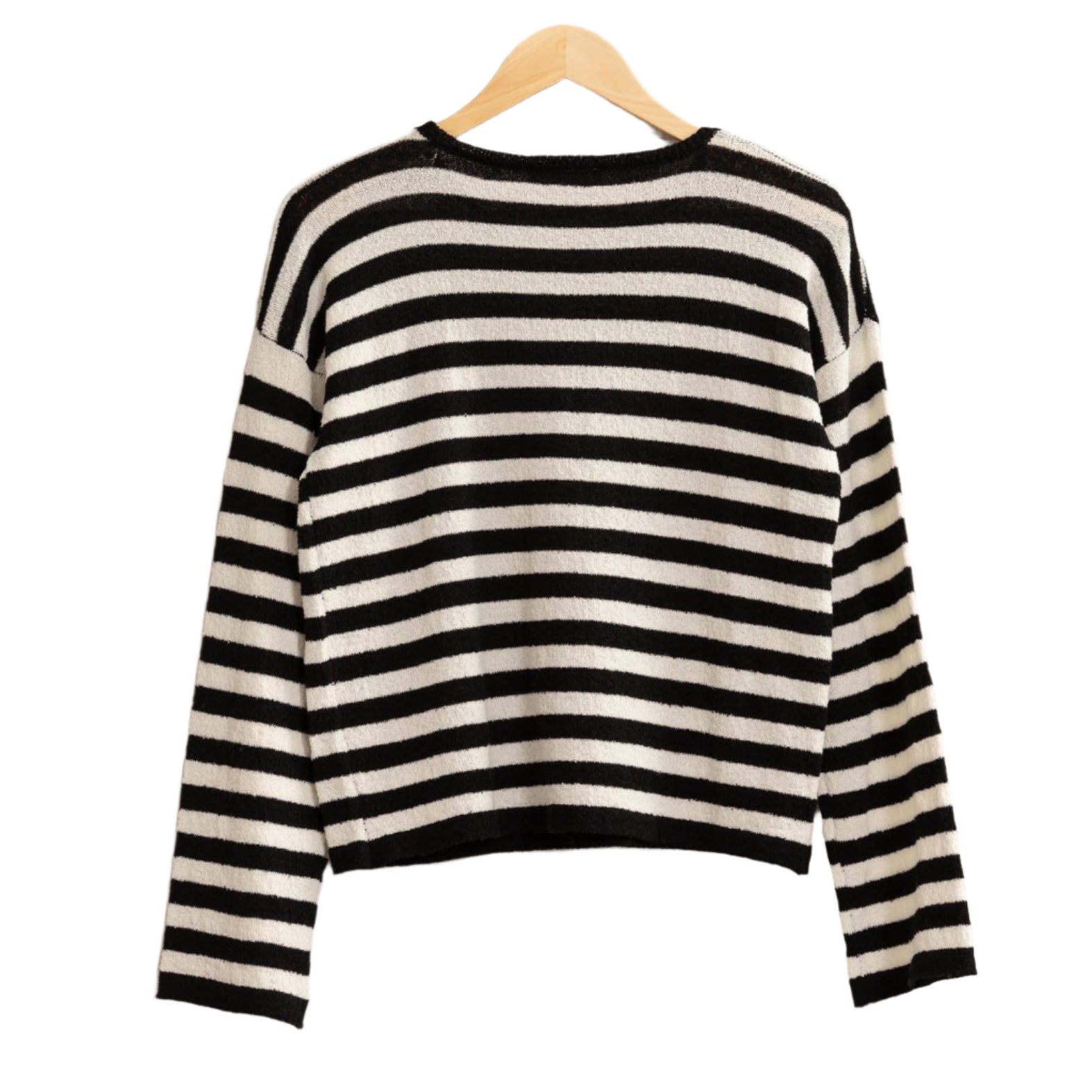 Black and white striped sweater on a hanger against a beige background