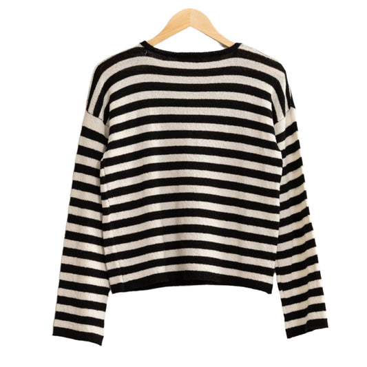 Black and white striped sweater on a hanger against a beige background
