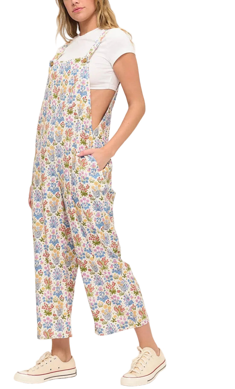 Woman wearing a floral overalls and white shirt on a white background