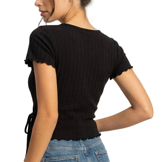 Woman wearing a black top and denim skirt on a plain background