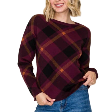 Woman wearing a plaid sweater and jeans against a plain background