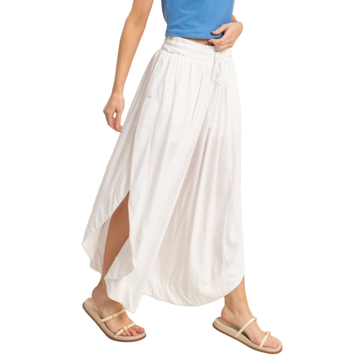 Person wearing a white skirt and blue top on a plain background