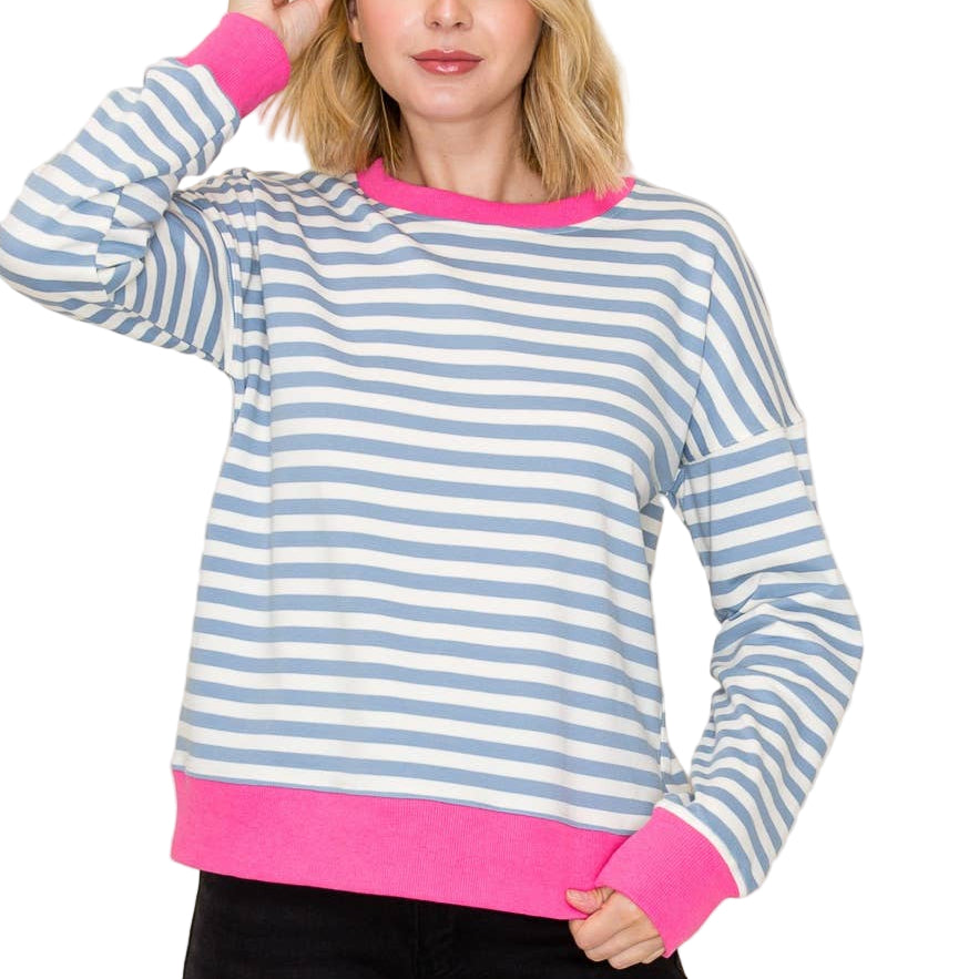 Woman wearing a blue and pink striped sweater with a plain background