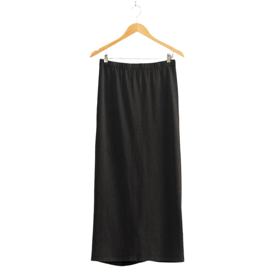 Black skirt on a wooden hanger against a beige wall