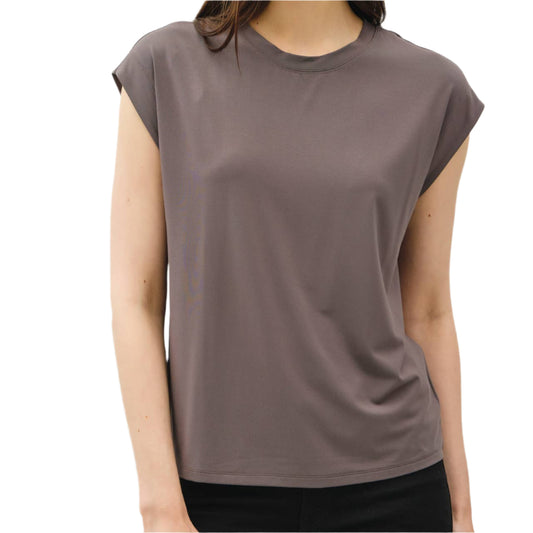 Woman wearing a brown sleeveless top against a plain background