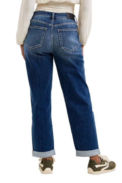 Person wearing blue jeans with a plain background