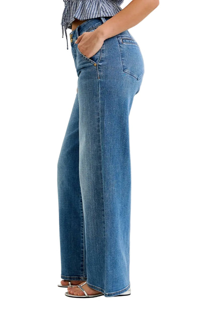 Person wearing blue jeans on a plain background