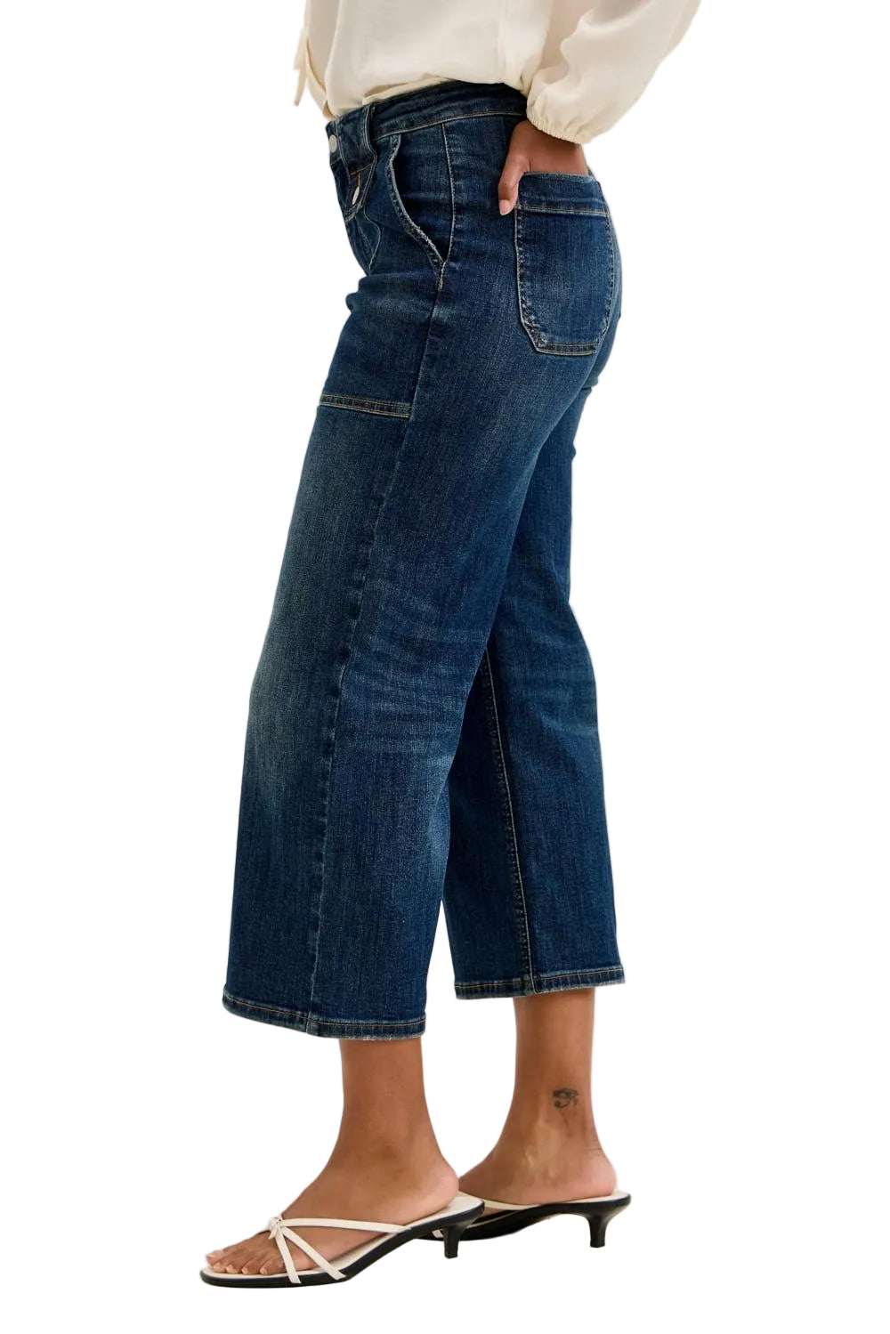 Person wearing blue jeans on a plain background