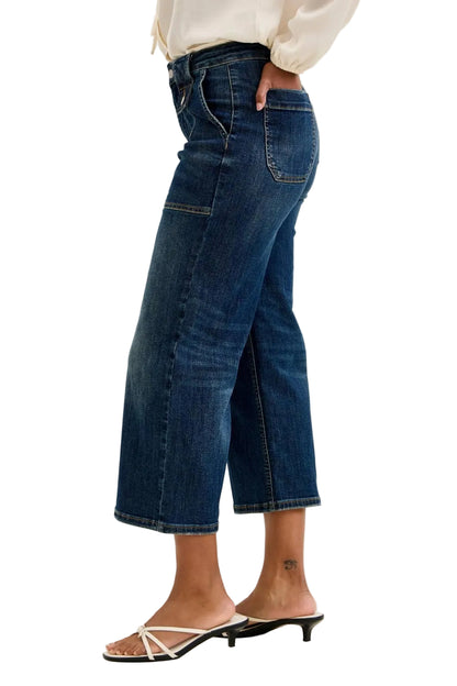 Person wearing blue jeans on a plain background