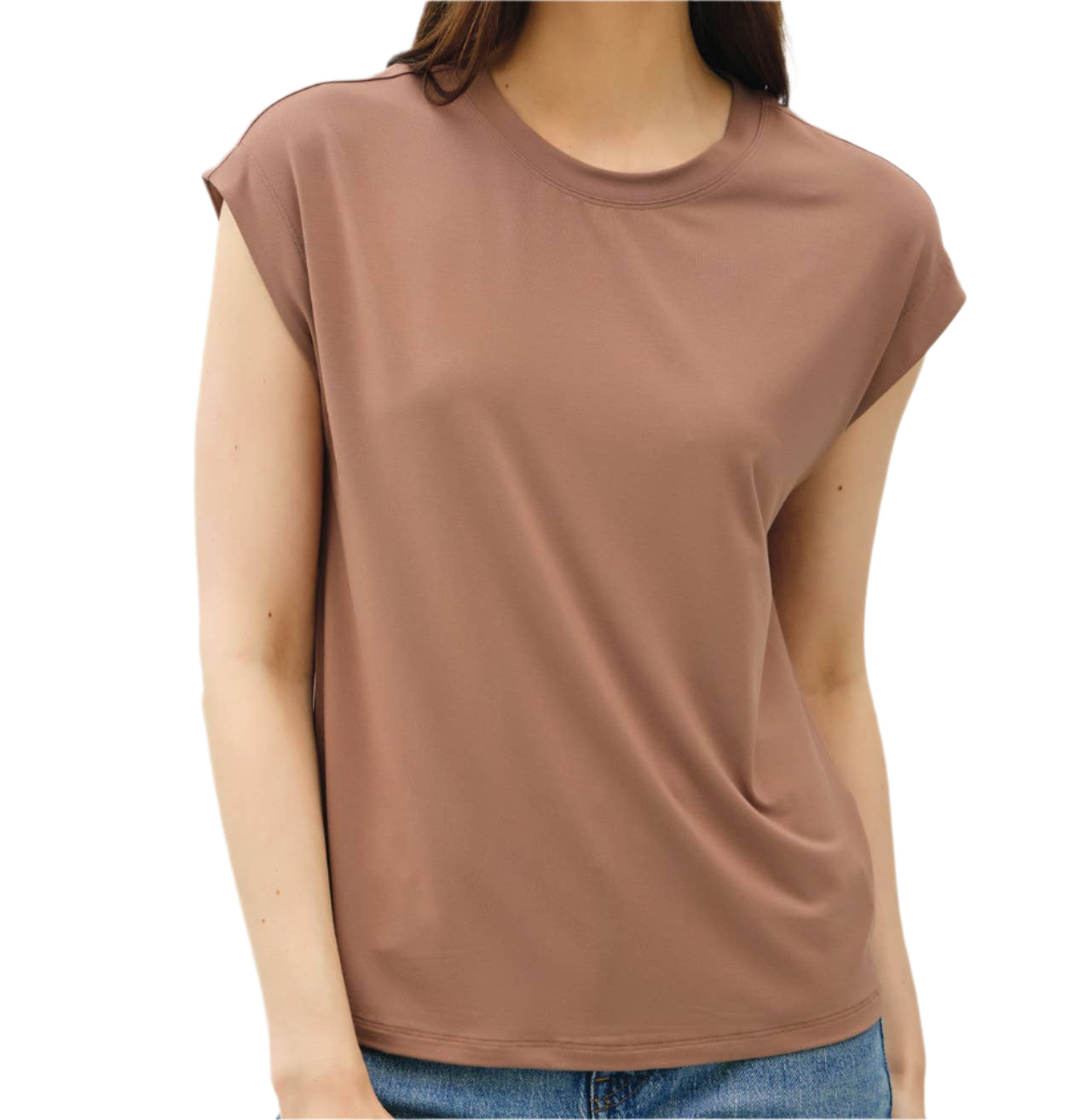 Woman wearing a brown sleeveless top and blue jeans against a plain background