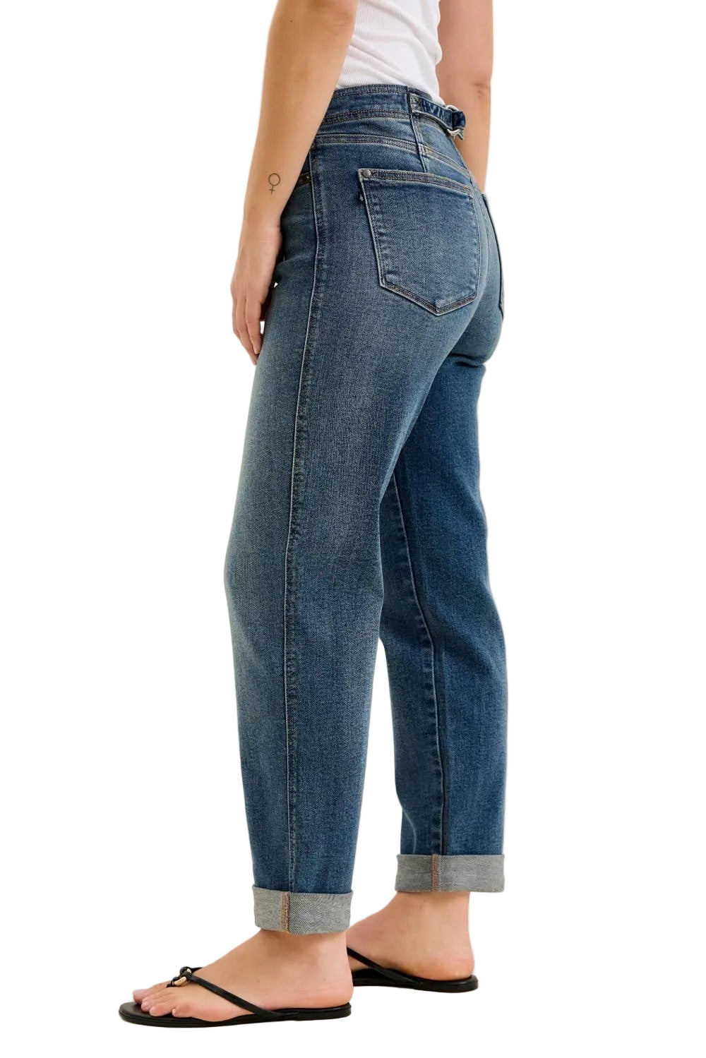 Person wearing blue jeans on a plain background