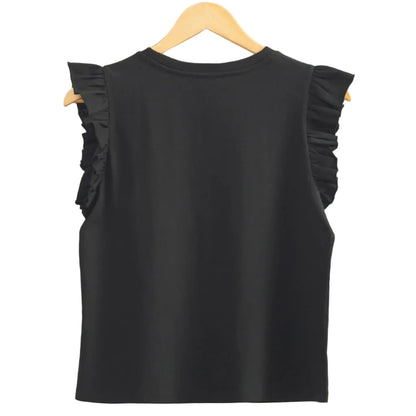 Black sleeveless top with ruffled shoulders on a hanger against a beige wall.