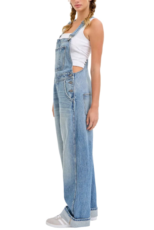 Woman wearing blue denim overalls on a white background