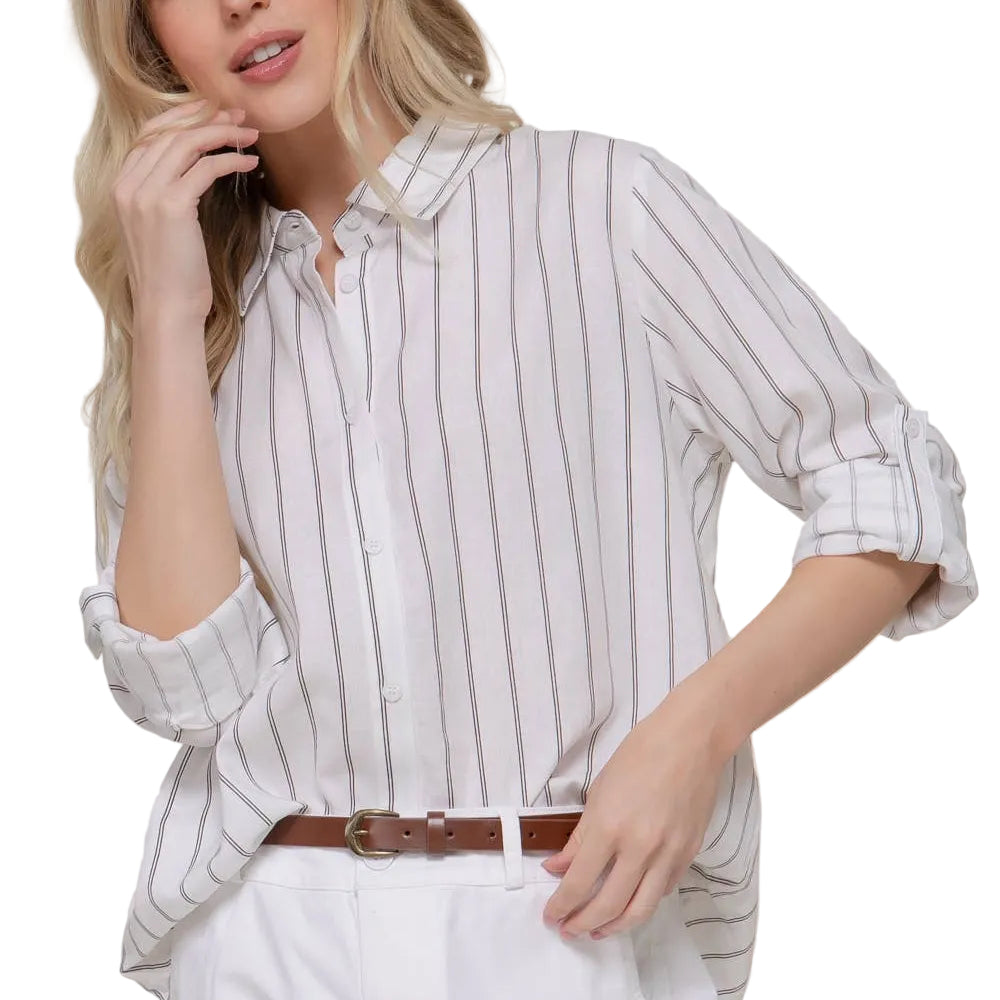 Woman wearing a striped shirt and white shorts against a plain background