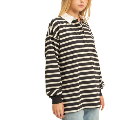 Woman wearing a black and white striped shirt with a plain background