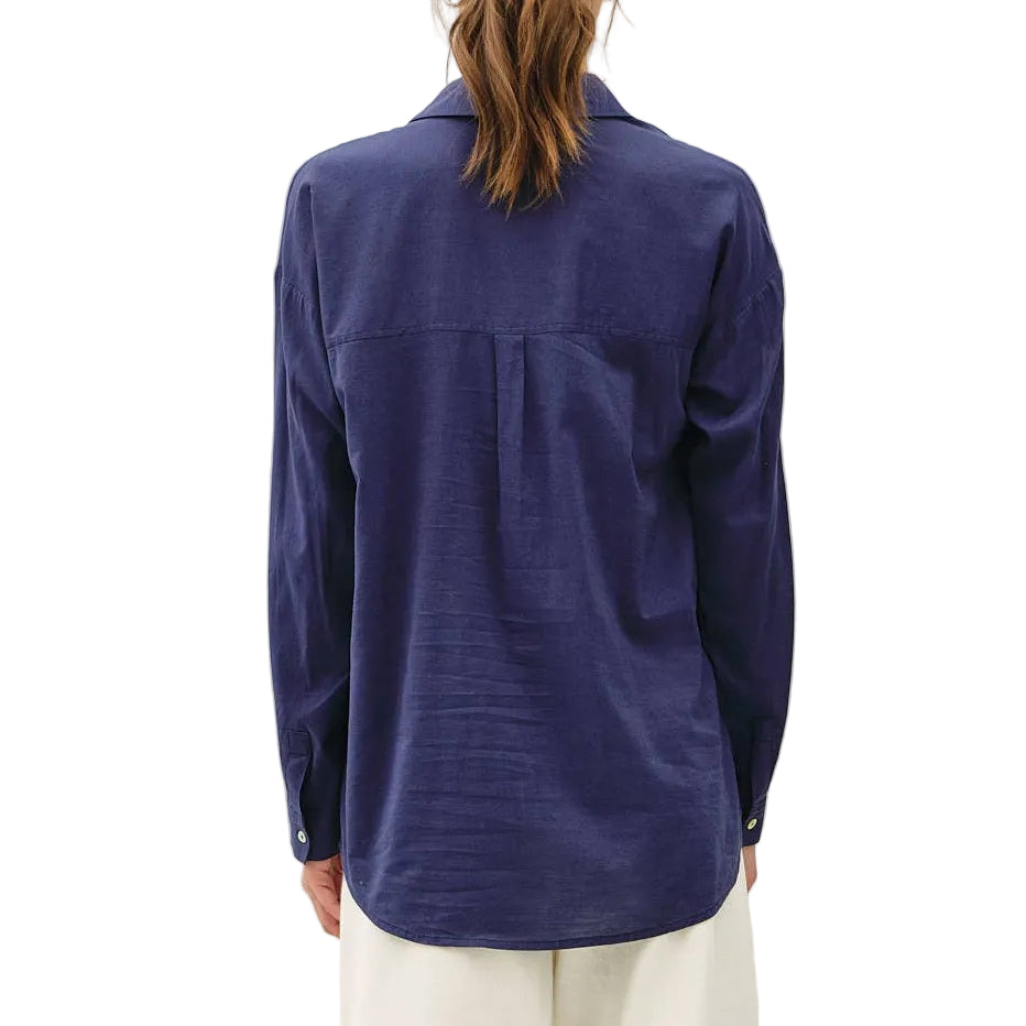 Person wearing a blue shirt and white pants on a white background