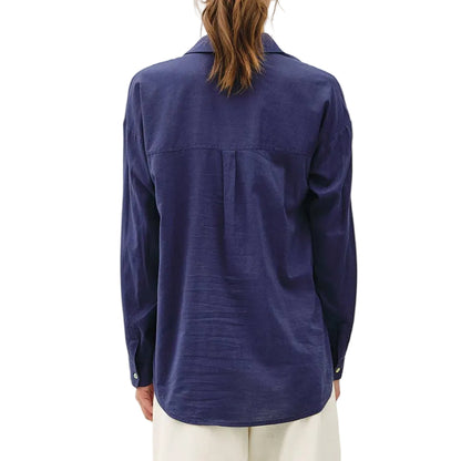 Person wearing a blue shirt and white pants on a white background