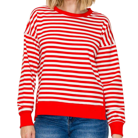 Woman wearing a red and white striped sweater against a plain background