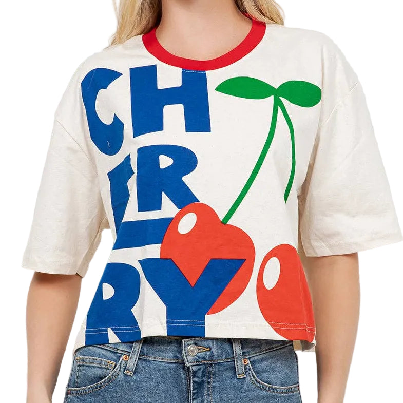 Woman wearing a white t-shirt with colorful graphics and text, standing against a light background.