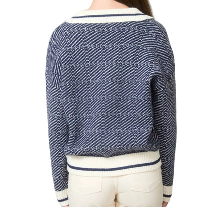 Person wearing a blue and white patterned sweater in an indoor setting.