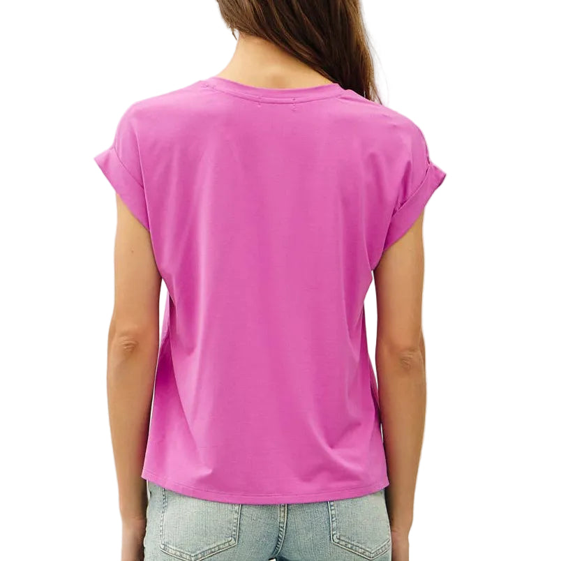 Person wearing a bright pink t-shirt and light blue jeans on a white background