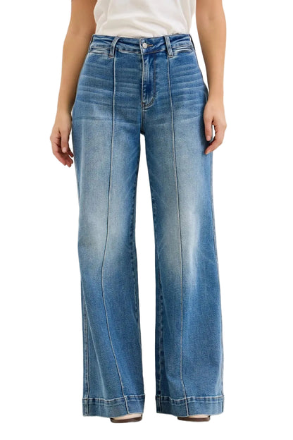 Blue jeans worn by a person on a beige background