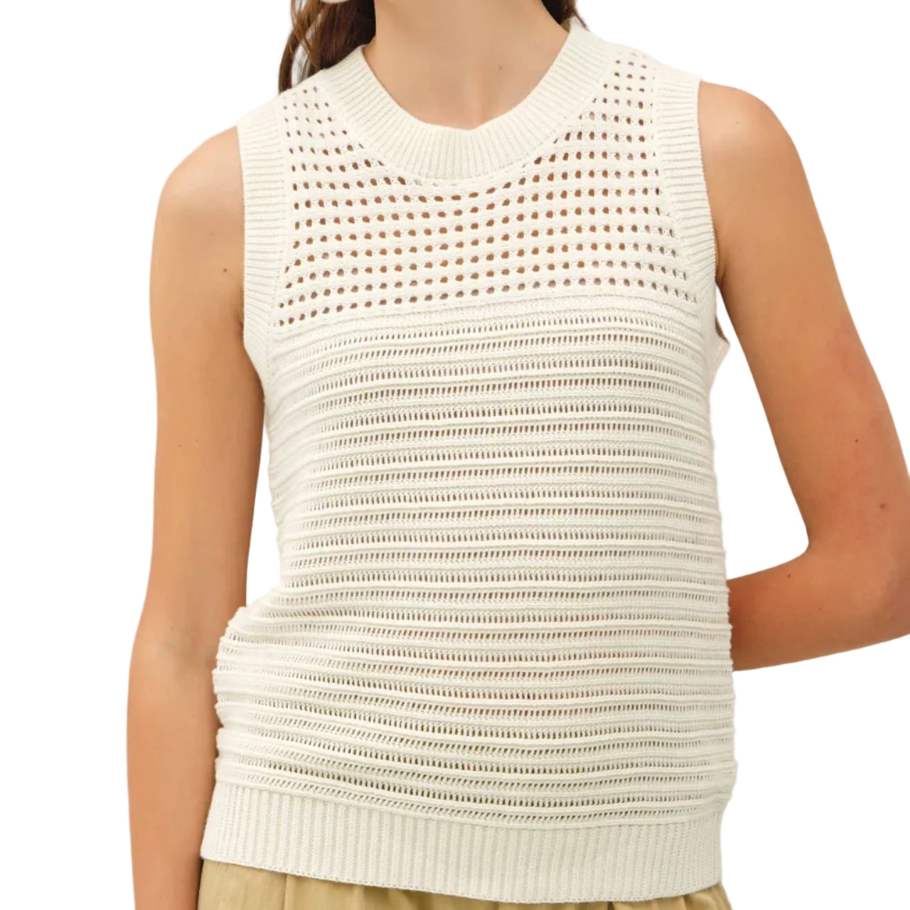 Woman wearing a white sleeveless knitted top against a plain background