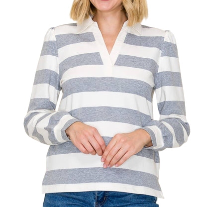 Woman wearing a blue and white striped shirt with jeans on a plain background