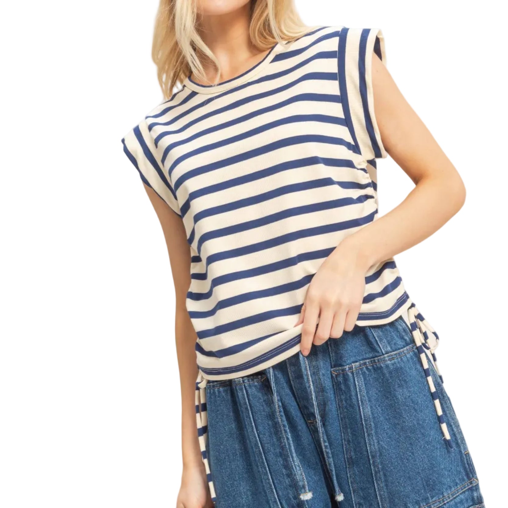 Woman wearing a blue and white striped top with denim pants on a plain background