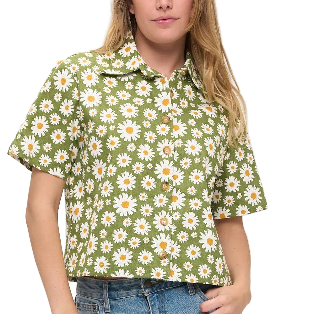 Woman wearing a green floral blouse with a plain background