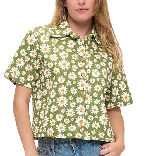 Woman wearing a green floral blouse with a plain background