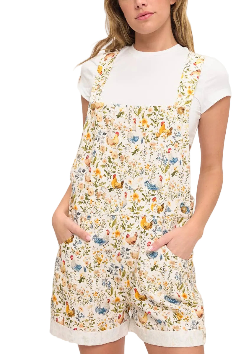Woman wearing a floral romper with a white shirt underneath on a white background