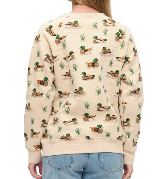 A woman viewed from the back wearing a cream-colored crewneck sweatshirt with an all-over print of mallards and reeds, paired with light blue jeans against a plain white background.